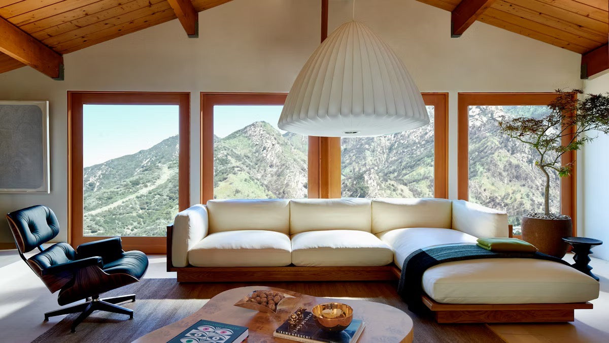 The Pawson Drift sectional sofa with the Eames Lounge and Ottoman in a living room.