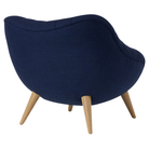 The Rohde Easy Chair from Herman Miller with the inkpad beck upholstery and oak leg finish from the back at an angle.