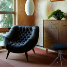 The Rohde Easy Chair from Herman Miller with the obsidian prone leather upholstery in a primary bedroom.