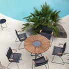 Click Outdoor Dining Chair Tall Back by Houe chairs grouped around a dining table beside a swimming pool outdoor setting.