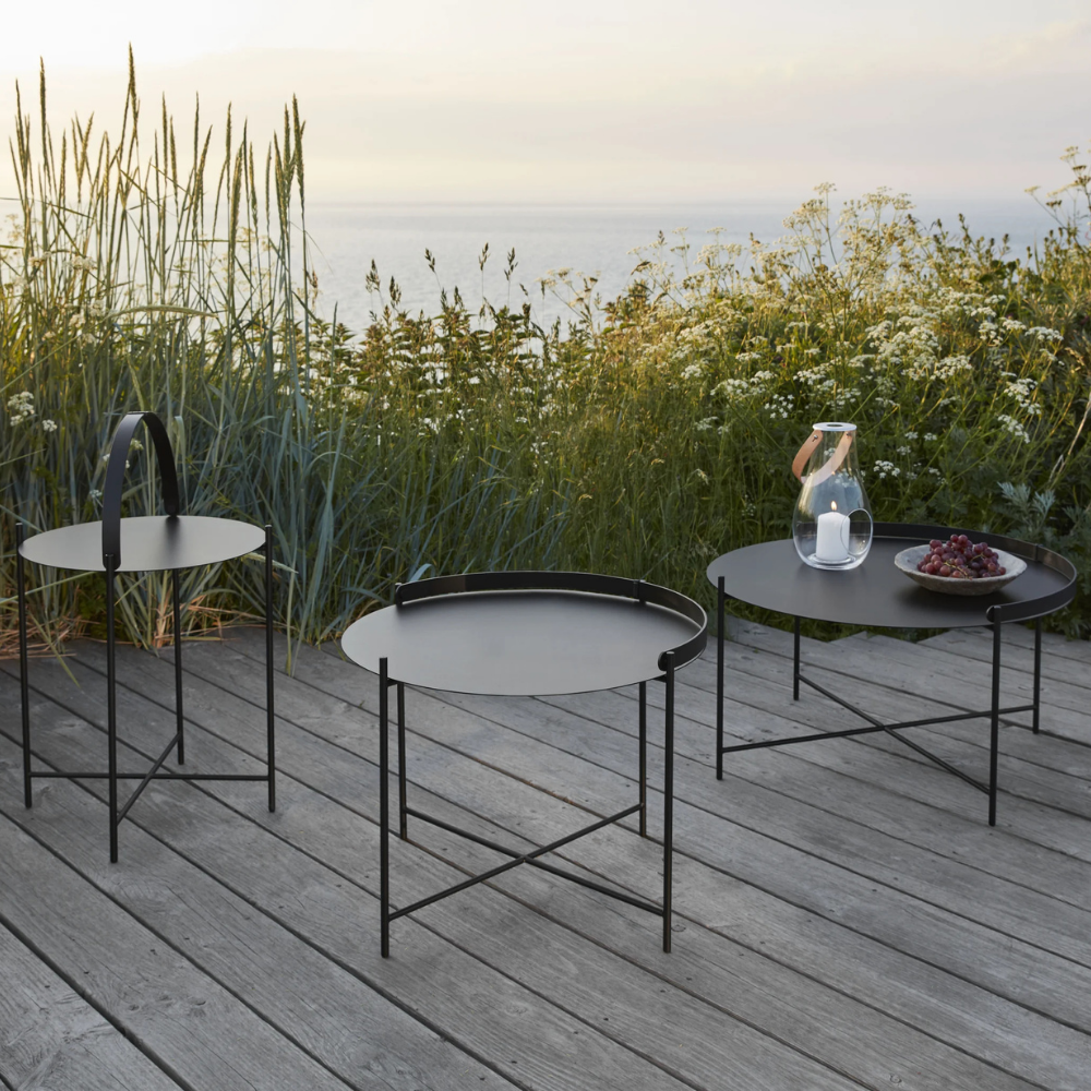 The Edge Outdoor Tray Side Table and Edge Tray Coffee Table in Medium and large by Houe on a patio. 