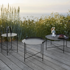 The Edge Outdoor Tray Side Table and Edge Tray Coffee Table in Medium and large by Houe on a patio. 