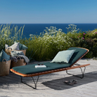 The Molo Sunbed Cushion by Houe with sunbeds on a wooden deck overlooking the ocean.