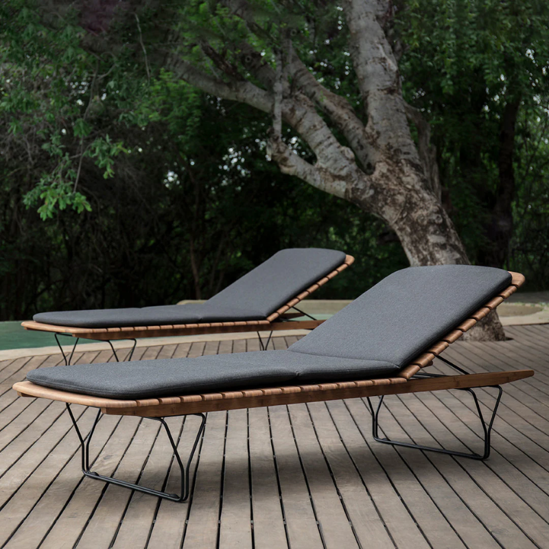 The Molo Sunbed Cushion by Houe with two sunbeds on a wooden deck.