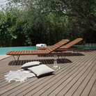 The Molo Sunbed by Houe on the wooden deck is upright.
