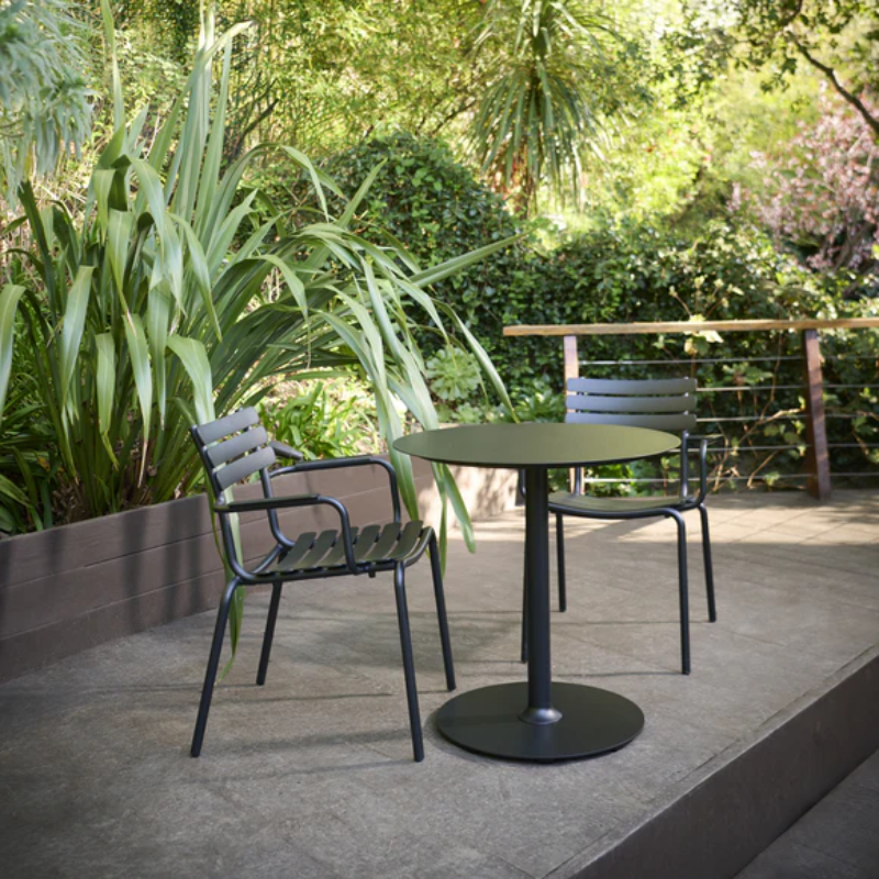 The Pico Round Cafe Table Round Base by Houe in a cafe outdoor seating area with chairs. all-groups