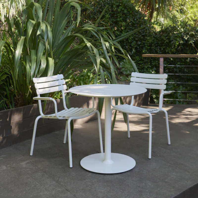 The Pico Round Cafe Table Round Base by Houe in an outdoor area with chairs. all-groups