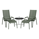 The ReClips Outdoor Footrest by Houe with chairs and a round table setting.
