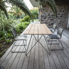 The Sketch Outdoor Dining Table from Houe on the balcony with chairs.