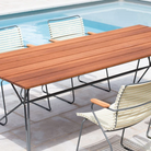 The small Sketch Outdoor Dining Table from Houe with a chair beside the pool.