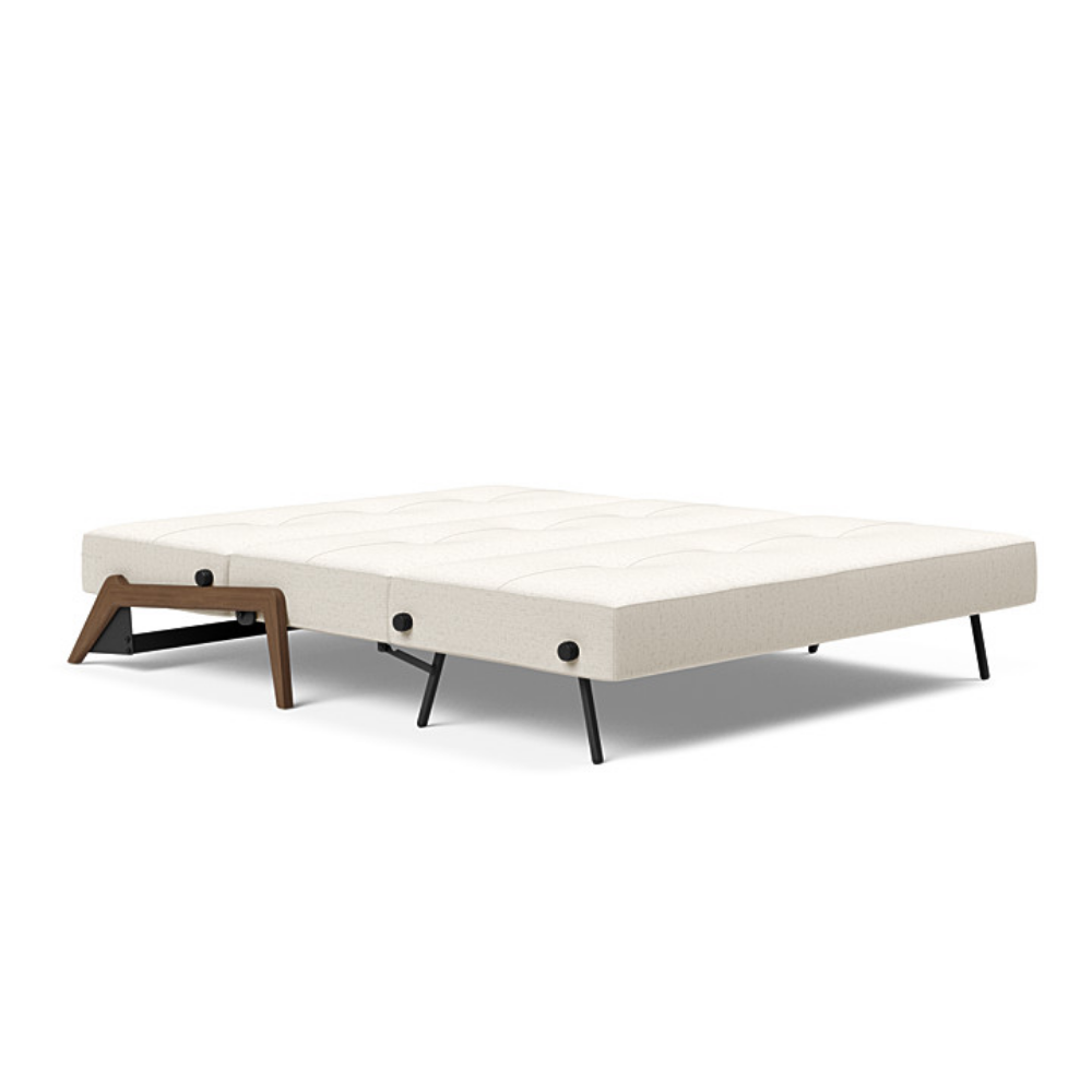 The Cubed Queen Size Sleeper Sofa with Wood Legs from Innovation Living with dark lacquered oak legs and boucle off white 531 upholstery setup as a bed.