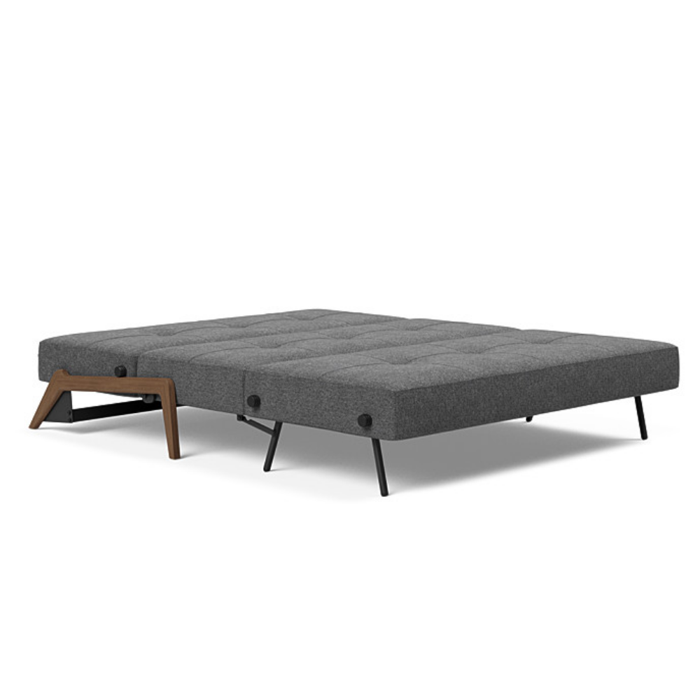 The Cubed Queen Size Sleeper Sofa with Wood Legs from Innovation Living with dark lacquered oak legs and taura deep grey 350 upholstery setup as a bed.