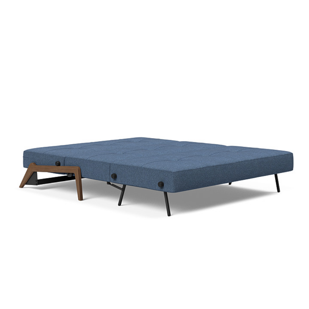 The Cubed Queen Size Sleeper Sofa with Wood Legs from Innovation Living with dark lacquered oak legs and weda blue 302 upholstery setup as a bed.
