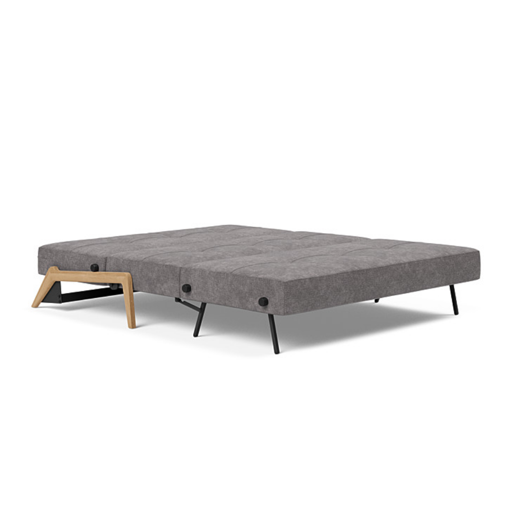 The Cubed Queen Size Sleeper Sofa with Wood Legs from Innovation Living with lacquered oak legs and avella warm grey 282 upholstery setup as a bed.