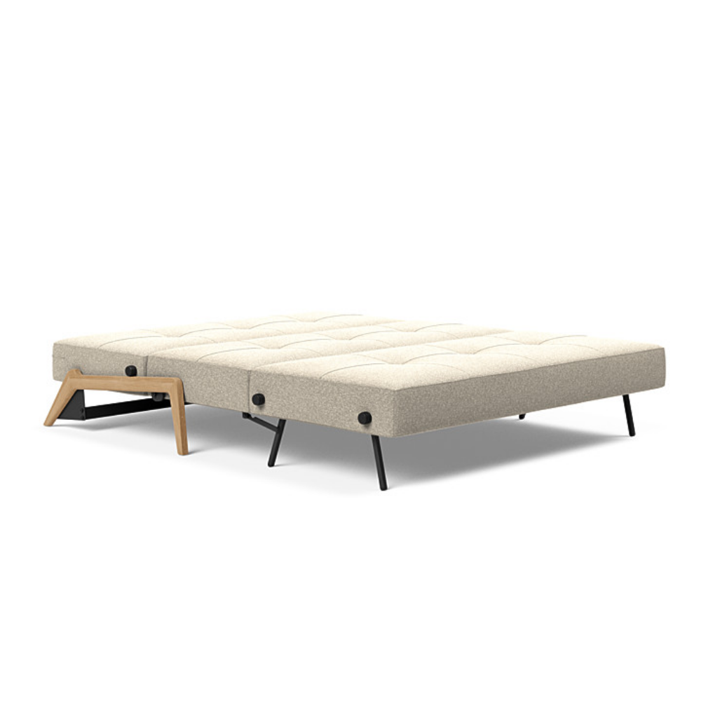 The Cubed Queen Size Sleeper Sofa with Wood Legs from Innovation Living with lacquered oak legs and boucle beige 539 upholstery setup as a bed.