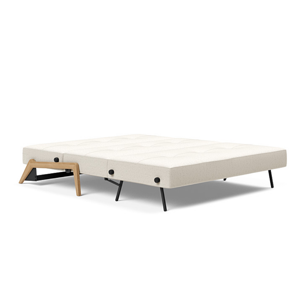 The Cubed Queen Size Sleeper Sofa with Wood Legs from Innovation Living with lacquered oak legs and boucle off white 531 upholstery setup as a bed.
