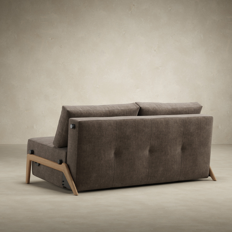 The Cubed Queen Size Sleeper Sofa with Wood Legs from Innovation Living with lacquered oak legs and esina cedar brown 411 upholstery from the back in a living room.
