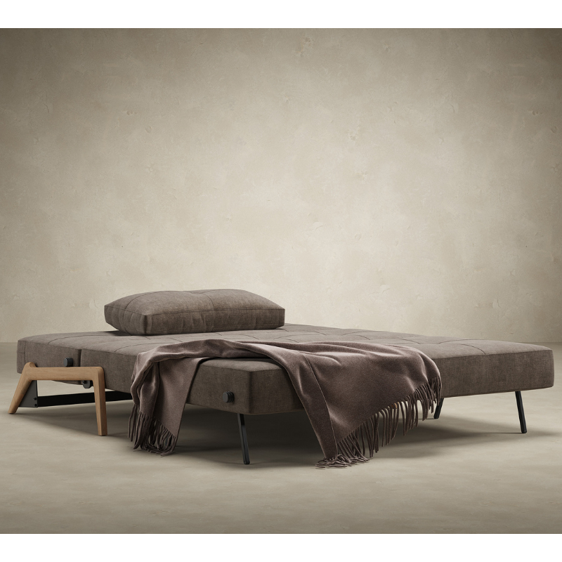 The Cubed Queen Size Sleeper Sofa with Wood Legs from Innovation Living with lacquered oak legs and esina cedar brown 411 upholstery opened into a bed in a family area.