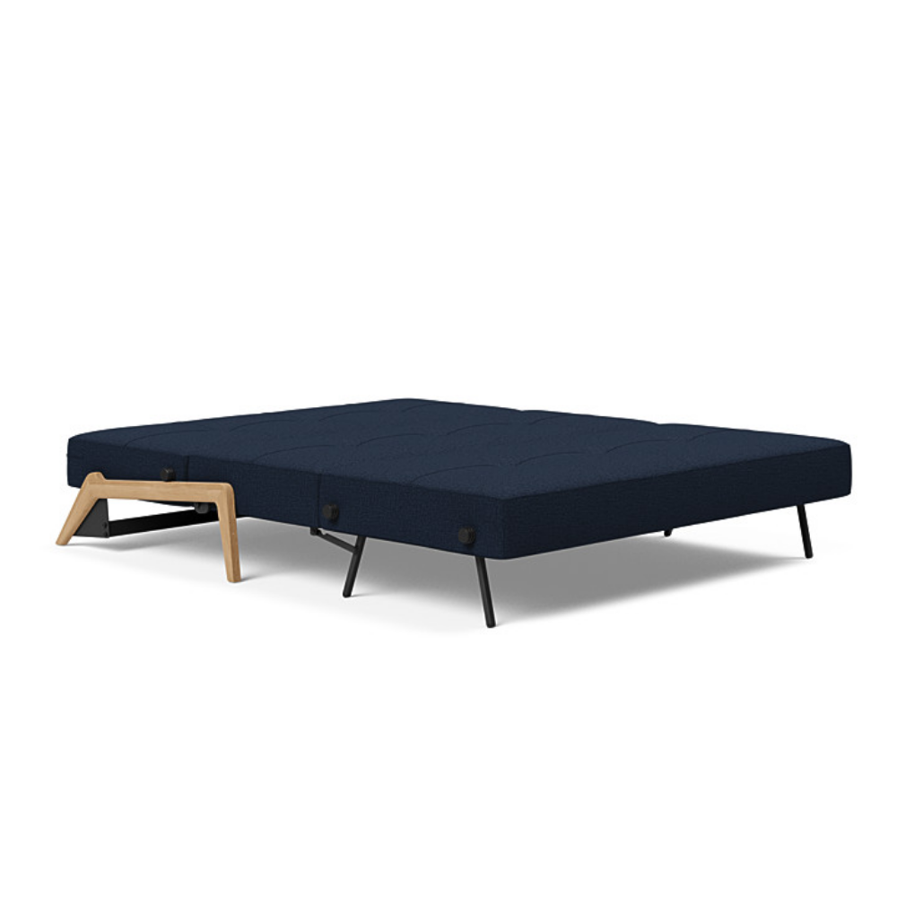 The Cubed Queen Size Sleeper Sofa with Wood Legs from Innovation Living with lacquered oak legs and mixed dance blue 528 upholstery setup as a bed.