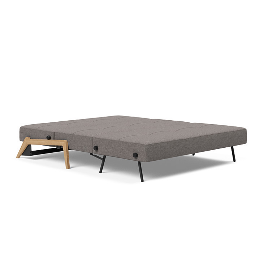 The Cubed Queen Size Sleeper Sofa with Wood Legs from Innovation Living with lacquered oak legs and mixed dance grey 521 upholstery setup as a bed.