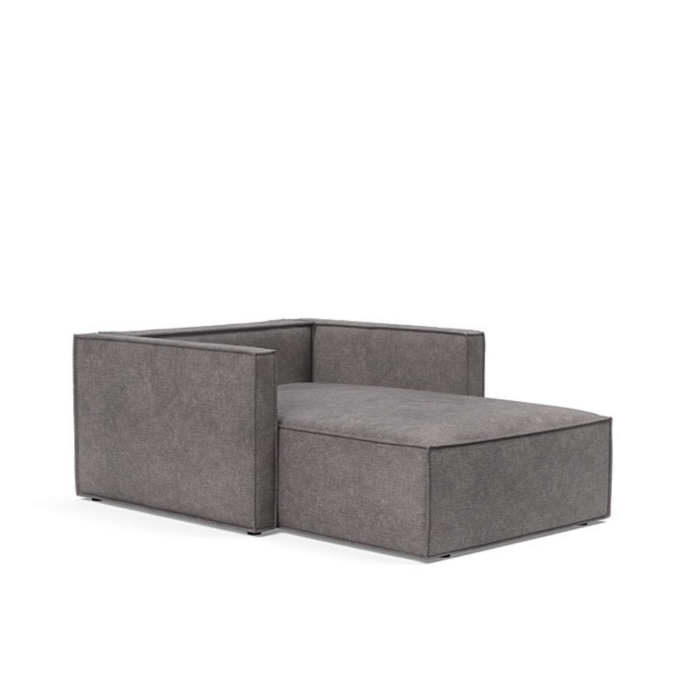 The Newilla Lounger Chair with Slim Arms with avella warm grey 282 upholstery without the cushion, setup as a bed.