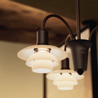 Up close image of the PH 1/1 Chandelier, 3-Light by Louis Poulsen turned on.