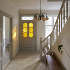 The PH 1/1 Chandelier, 6-Light by Louis Poulsen in an entryway turned off.