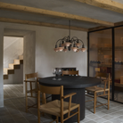 The PH 1/1 Chandelier, 9-Light by Louis Poulsen over a dining table turned off.