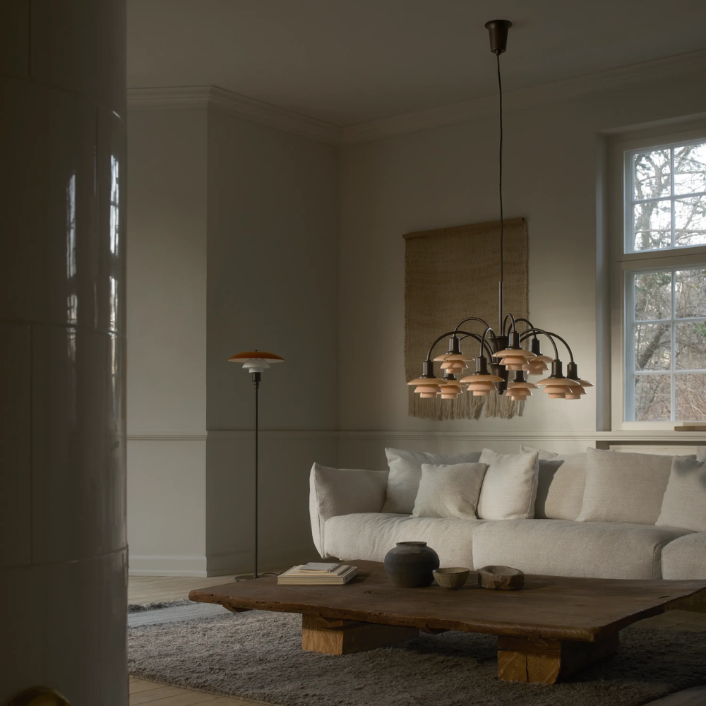 The PH 1/1 Chandelier, 9-Light by Louis Poulsen in a living room turned off.