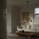 The PH 1/1 Chandelier, 9-Light by Louis Poulsen in a living room turned off.