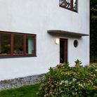 The AJ Eklipta Outdoor from Louis Poulsen next to a doorway. all-groups