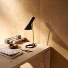 the AJ Mini Table Lamp in Brass and Black on a table.
