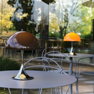 The Panthella 250 Portable Table Lamp from Louis Poulsen in Original Opal Brown turned on and turned off on an outdoor patio.