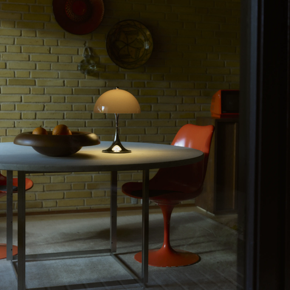 The Panthella 250 Portable Table Lamp from Louis Poulsen in Original Opal Brown on a dining room table.