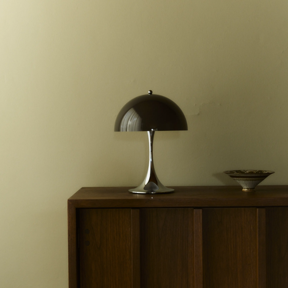 The Panthella 250 Portable Table Lamp from Louis Poulsen in Original Opal Brown on a credenza turned off.