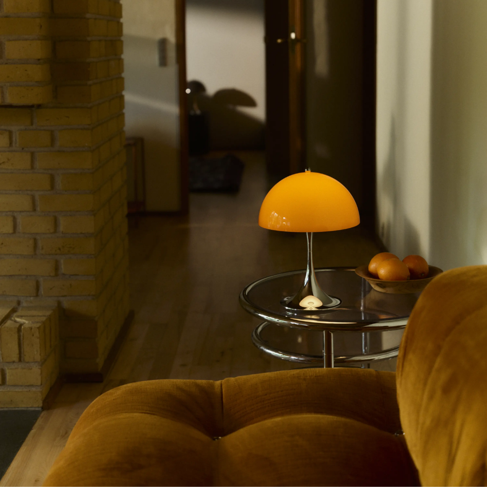 The Panthella 250 Portable Table Lamp from Louis Poulsen in Original Opal Orange in a living room.