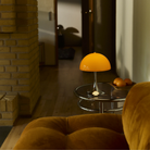 The Panthella 250 Portable Table Lamp from Louis Poulsen in Original Opal Orange in a living room.