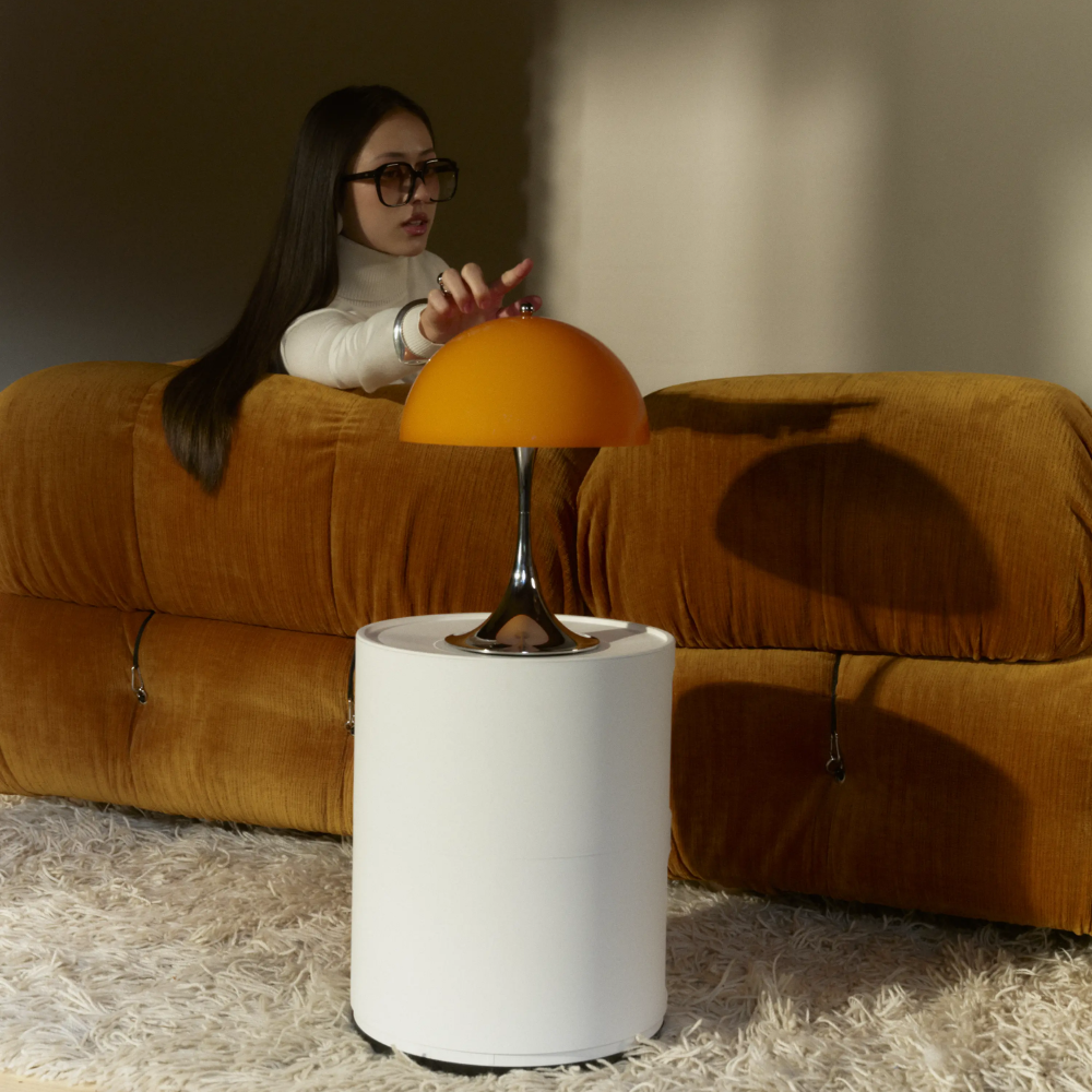 The Panthella 250 Portable Table Lamp from Louis Poulsen in Original Opal Orange in a living room.