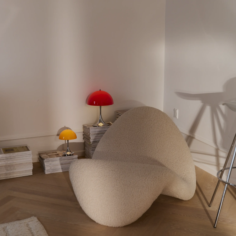 The Panthella 250 Portable Table Lamp from Louis Poulsen in Original Opal Red  in a living room.
