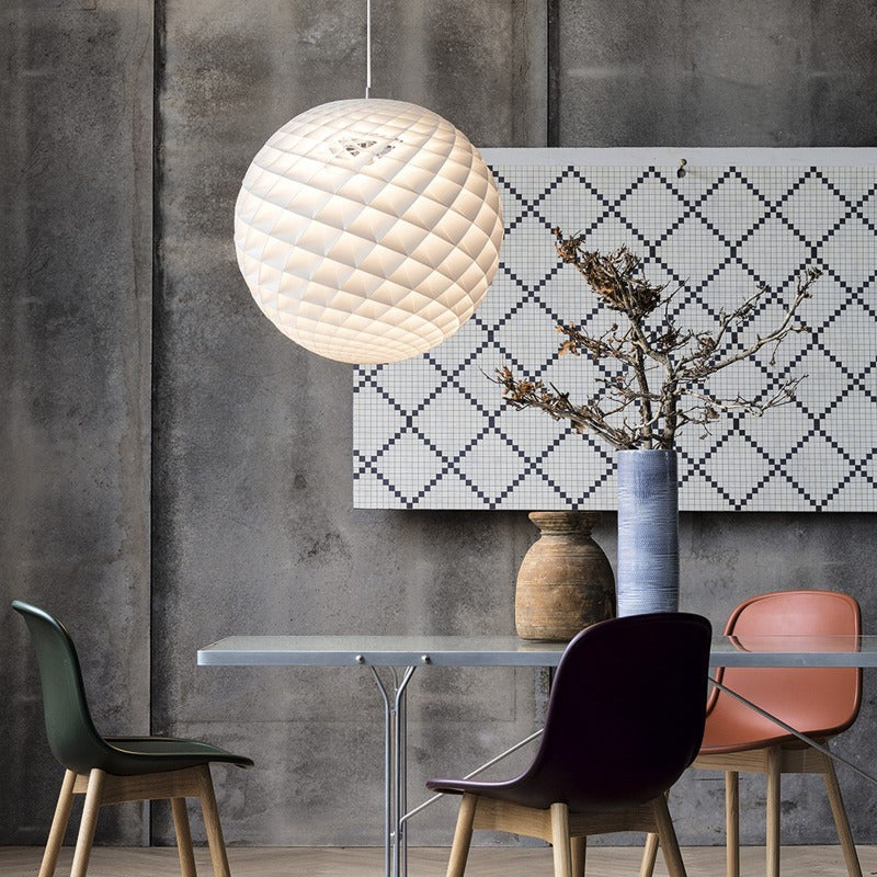 The Patera pendant is a glowing sphere built up of small diamond-shaped cells. Each cell is carefully designed to capture light and to shield the light source from the viewing angles above 45 degrees. Each cell glows. Below 45 degrees, the fields are open to direct light downwards. A small amount of light is also sent upwards to illuminate the ceiling. Designed by Danish designer Øivind Slaatto who took inspiration from the Fibonacci spiral. 