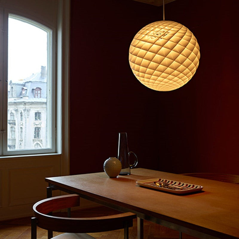The Patera pendant is a glowing sphere built up of small diamond-shaped cells. Each cell is carefully designed to capture light and to shield the light source from the viewing angles above 45 degrees. Each cell glows. Below 45 degrees, the fields are open to direct light downwards. A small amount of light is also sent upwards to illuminate the ceiling. Designed by Danish designer Øivind Slaatto who took inspiration from the Fibonacci spiral. 