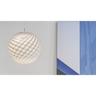 The Patera Pendant from Louis Poulsen in a living room.