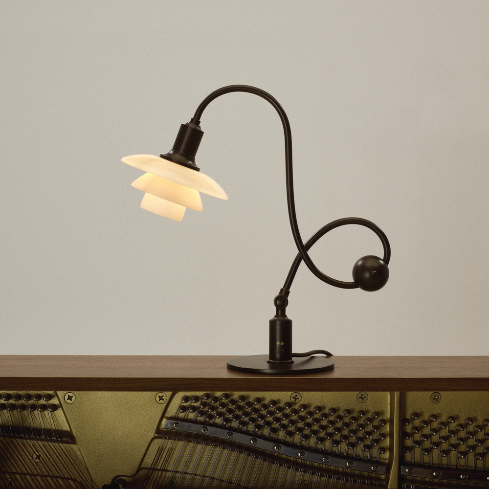 The PH 1/1 Piano Table Lamp by Louis Poulsen on a piano.