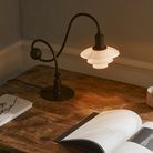 The PH 1/1 Piano Table Lamp by Louis Poulsen on a desk.