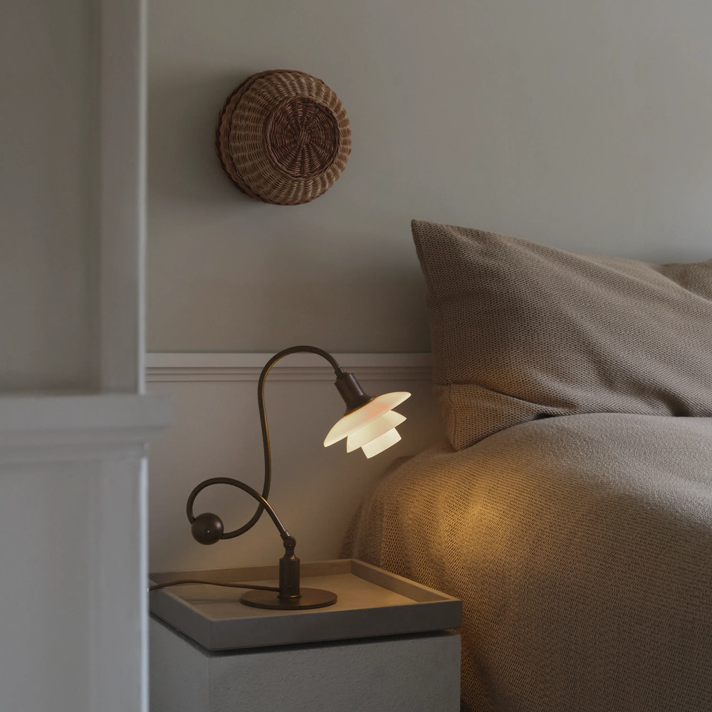 The PH 1/1 Piano Table Lamp by Louis Poulsen on a bedside table.