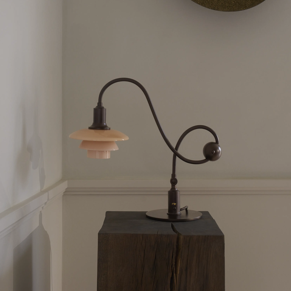 The PH 1/1 Piano Table Lamp by Louis Poulsen on a pedestal turned off.