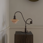 The PH 1/1 Piano Table Lamp by Louis Poulsen on a pedestal turned off.