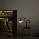 The PH 1/1 Piano Table Lamp by Louis Poulsen next to a piano.