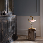 The PH 2/2 Question Mark Pale Rose Table Lamp from Louis Poulsen in a lounge lifestyle photograph.