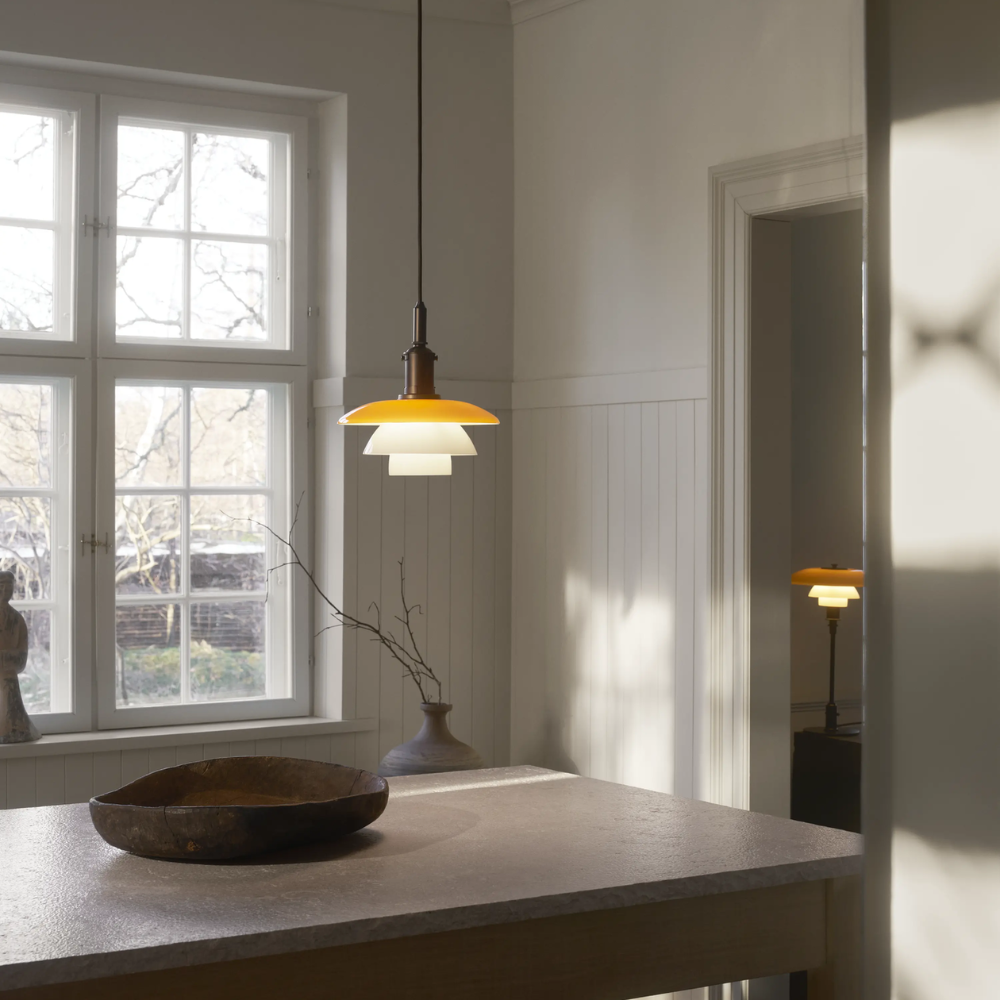 The PH 3/3 Pendant Centenary Edition by Louis Poulsen over a dining room table.
